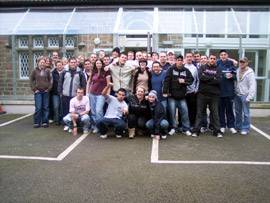 A large group of people standing in front of the glass corridor that runs along the side of our building.